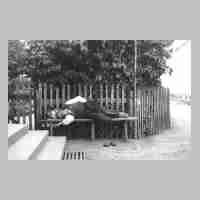 094-0070 Wirtschafter Pankoweit macht Mittagspause auf der Bank vor Darges Hauseingang.jpg